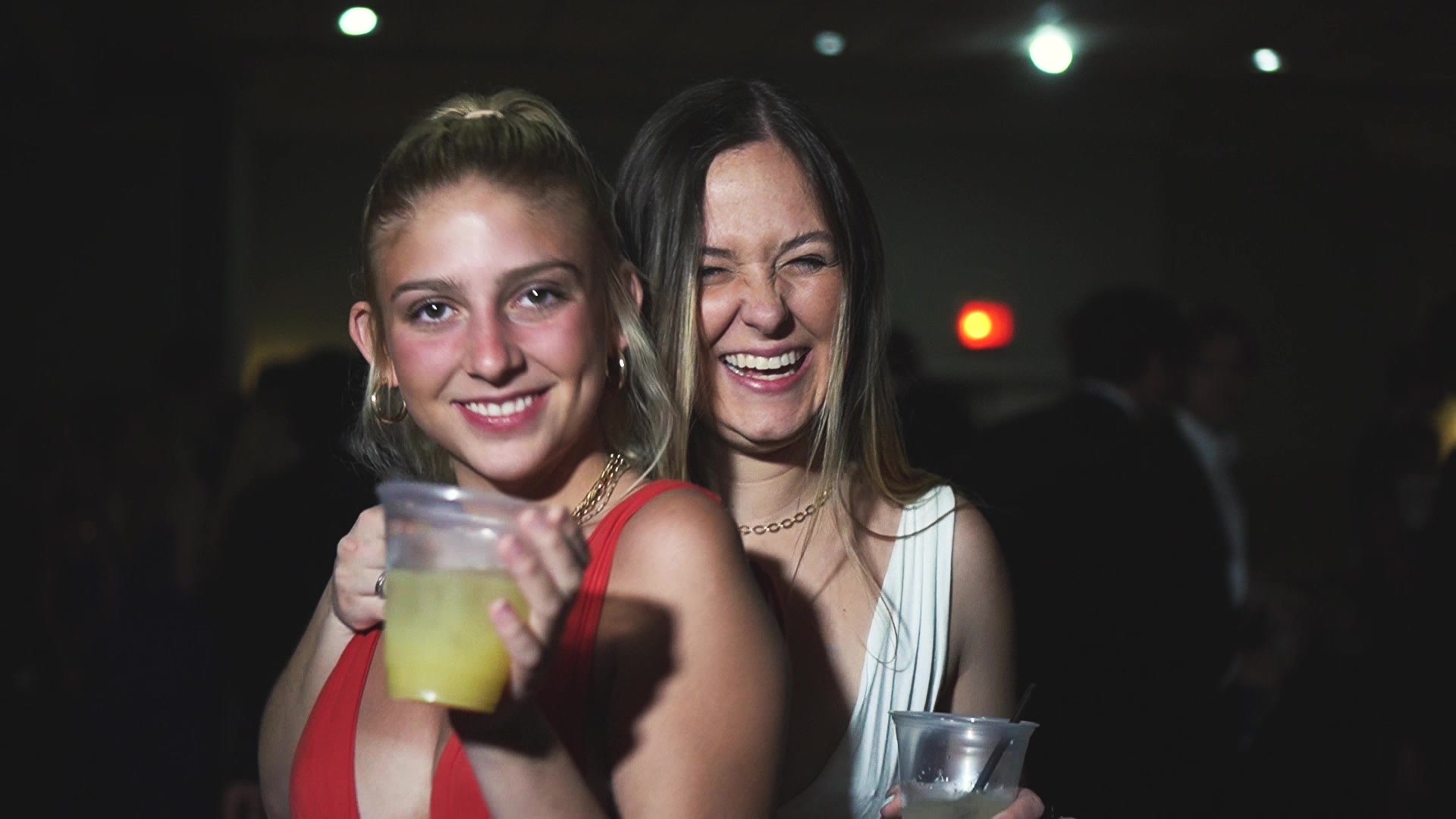 Two students smiling with drinks at a Myrtle Beach night party