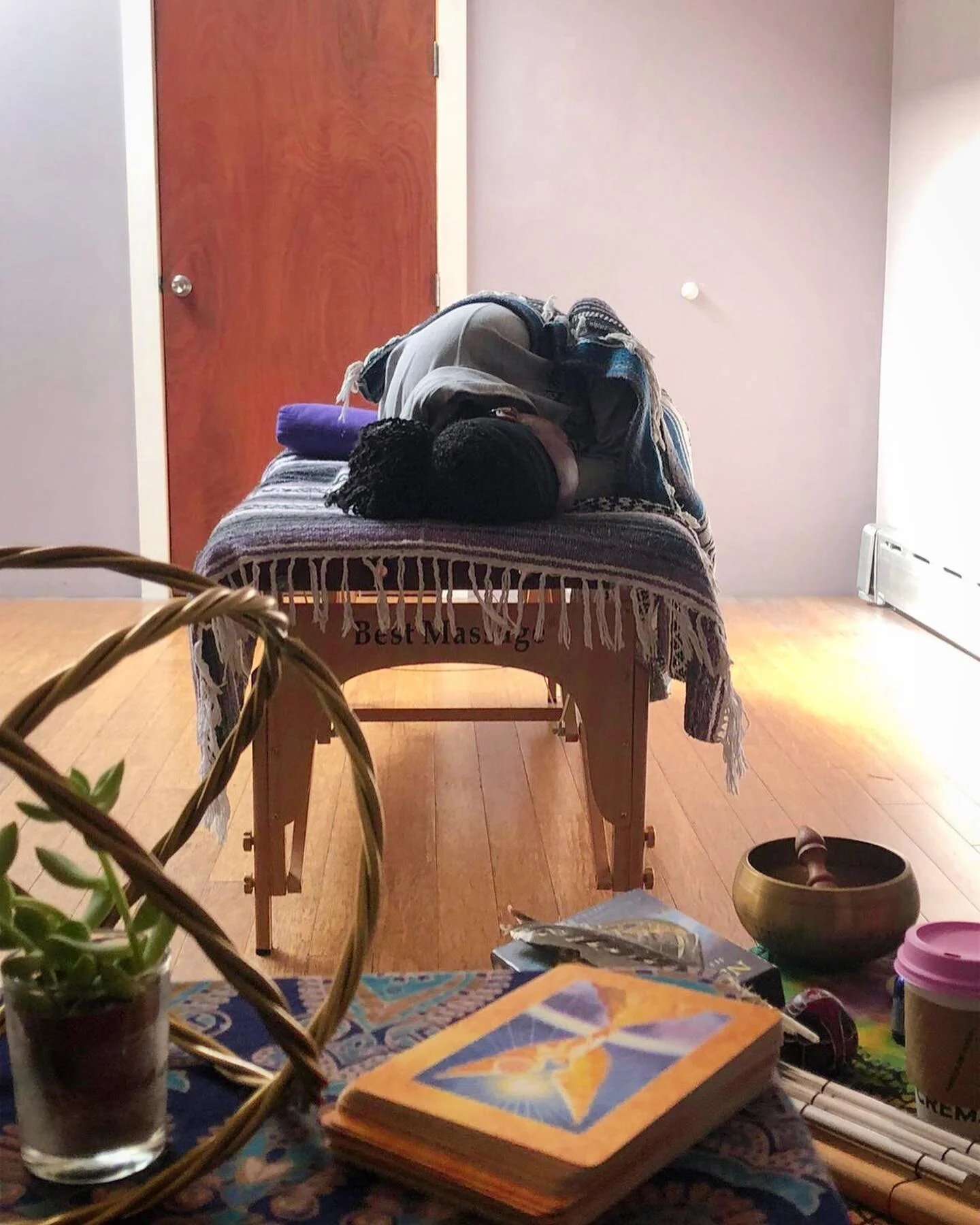 Wellness studio with massage table, singing bowl and plants