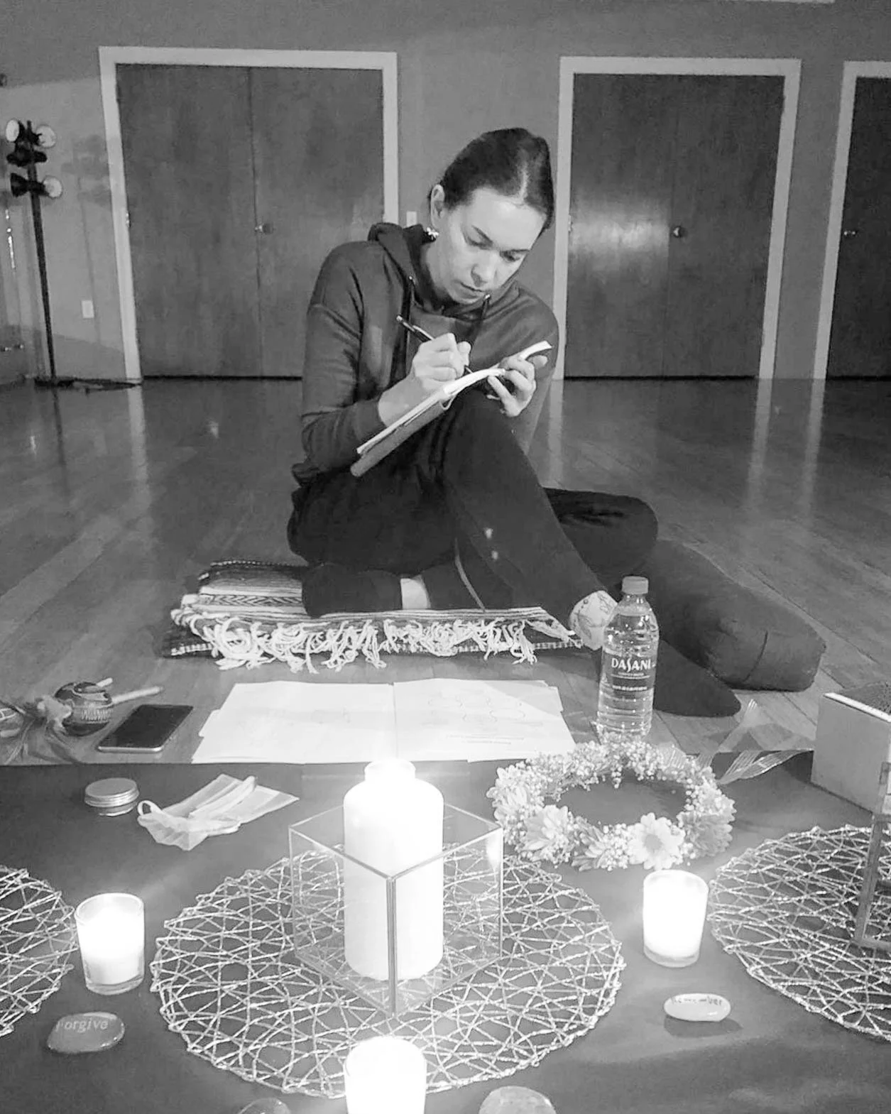 Woman journaling with candles and crystals, black and white