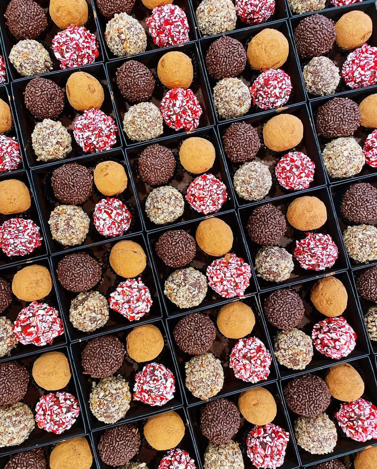 Grid of assorted chocolate truffles in black cups