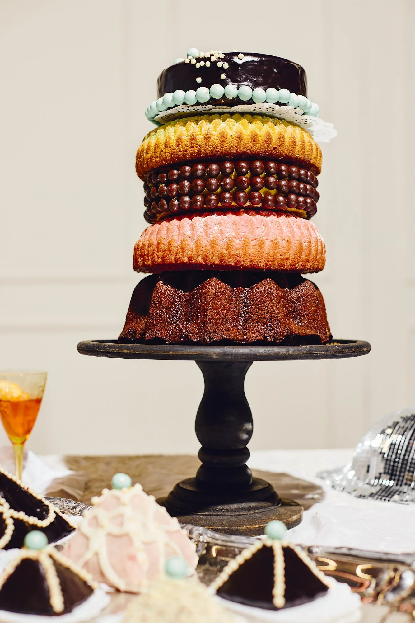 Stacked multi-layer bundt cake tower on a black stand