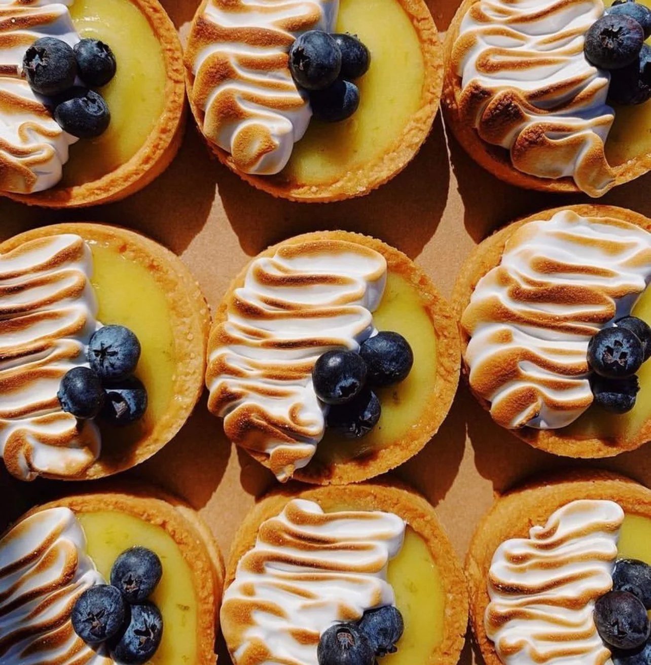Lemon meringue tarts topped with fresh blueberries