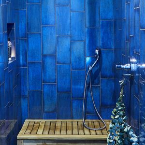 Cobalt blue tile shower interior with wooden bench