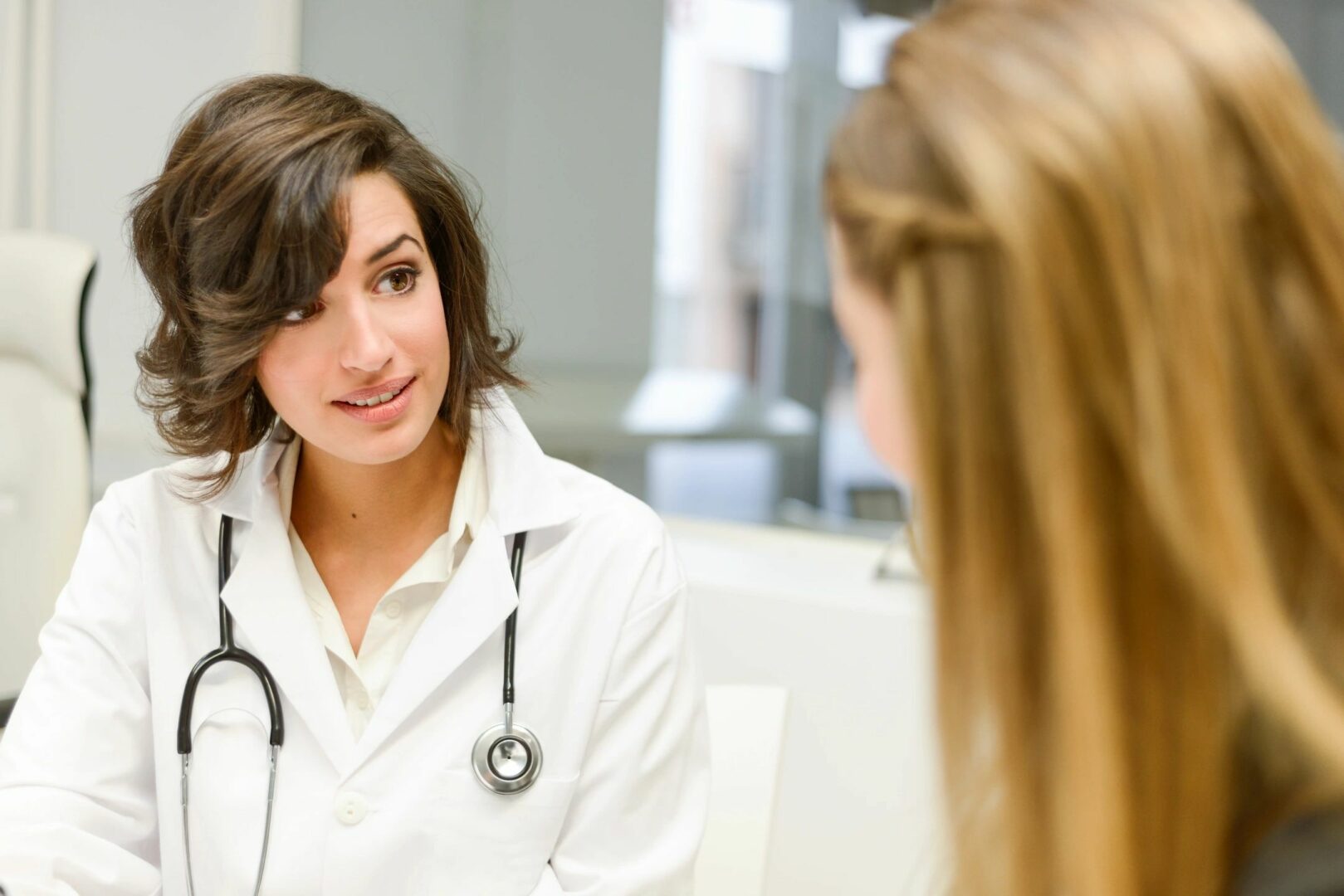 Female doctor with a stethoscope consulting a patient in a clinic