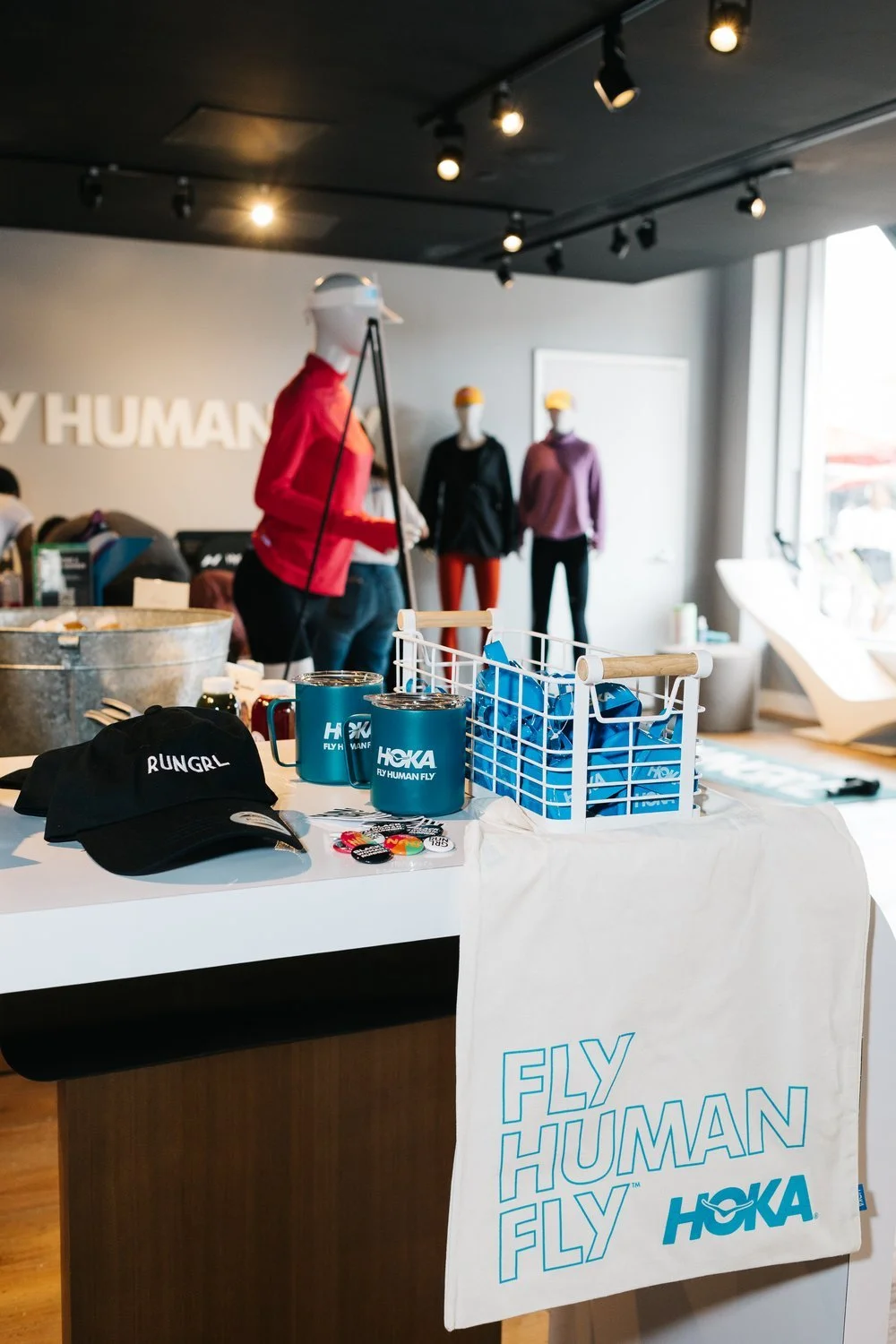 HOKA Fly Human Fly branded event display table with merchandise