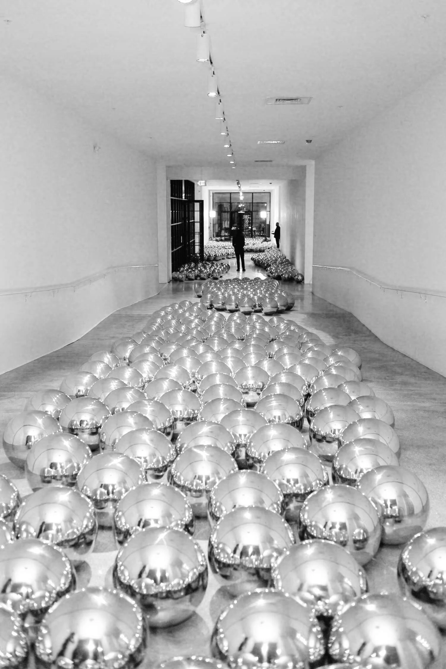 Gallery hallway filled with rows of silver mirror balls