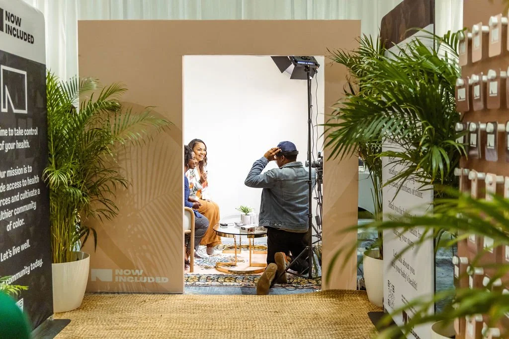 Photographer shooting two women in a branded event booth