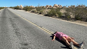Person lying on a desert road