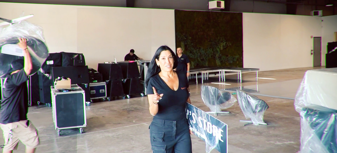 EventPros LA lead pointing to camera while crew sets up a large event venue