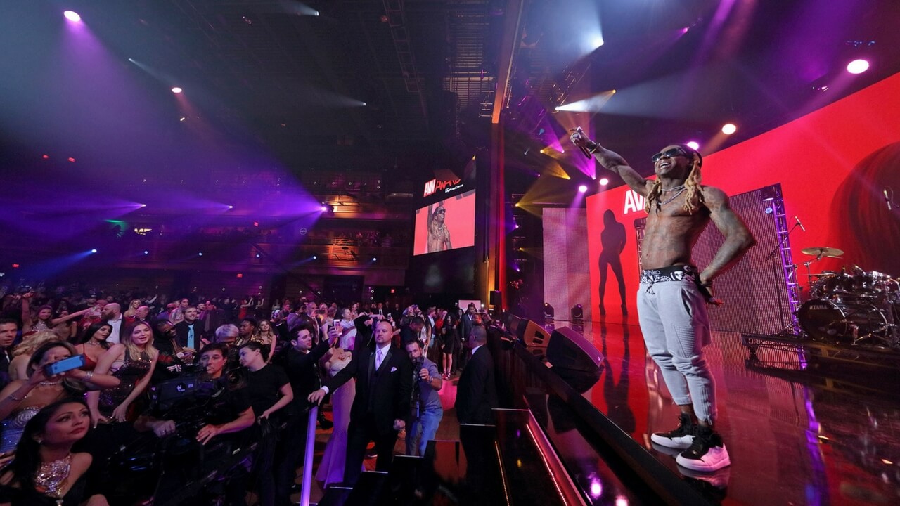 Performer on stage at AVN Awards show with crowd and large LED screens