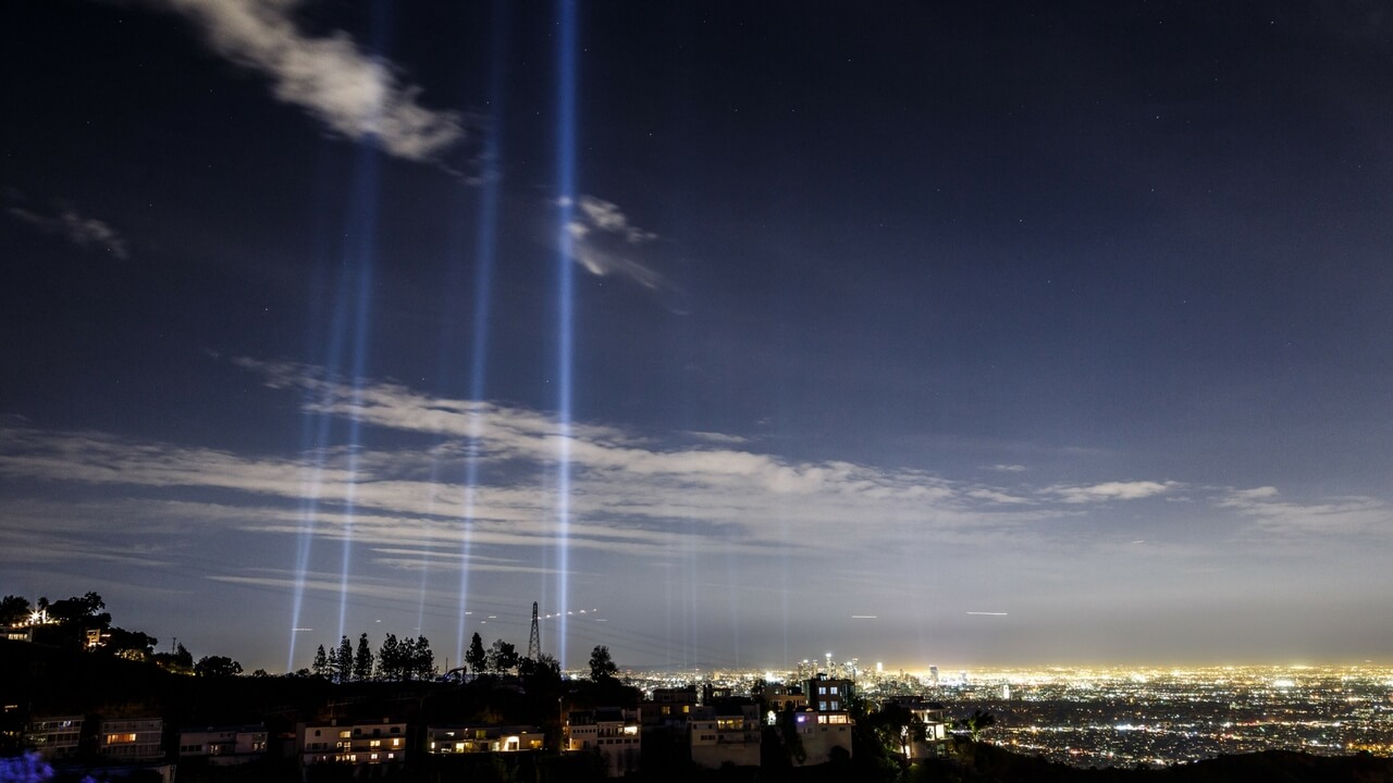 LA skyline at night with dramatic searchlight beams for the LA Marathon