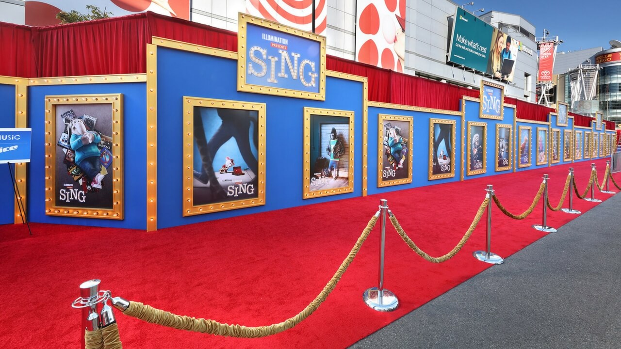 Sing movie premiere red carpet with elaborate blue and gold framed character poster wall