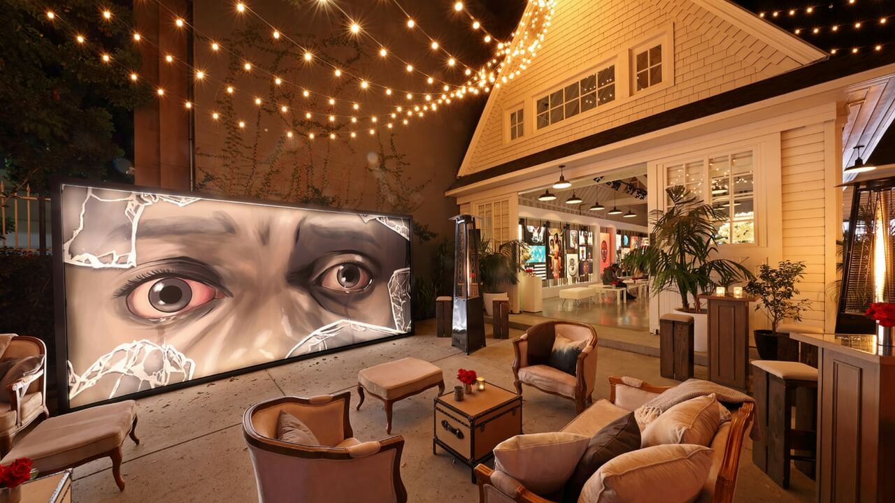 Outdoor nighttime event space for Get Out movie screening party with large display screen