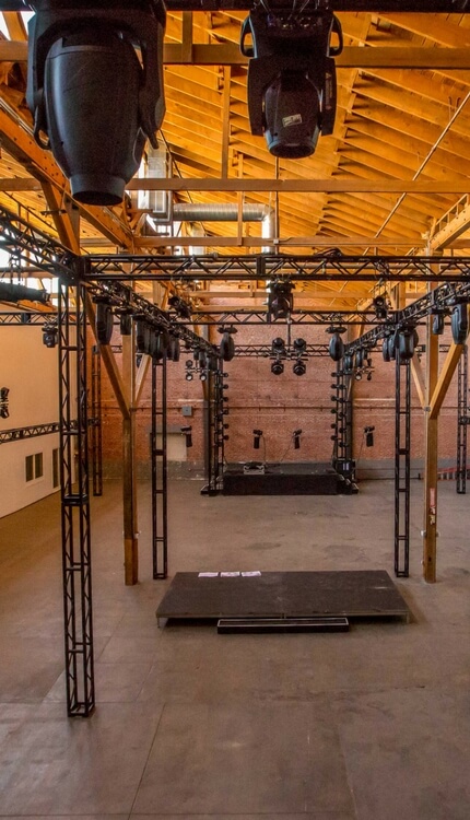 Event venue interior with stage lighting rigs and truss
