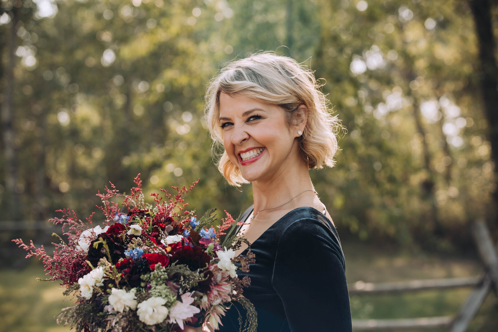 Jacqueline holding a colorful flower bouquet outdoors