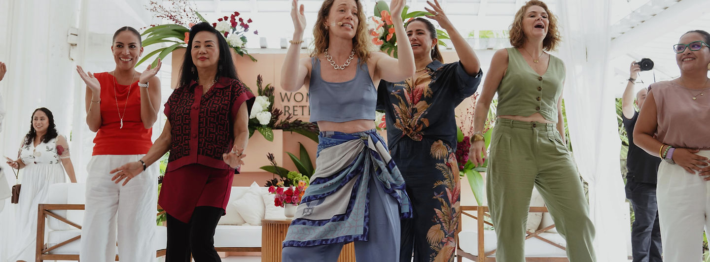 Women dancing and celebrating at an outdoor retreat