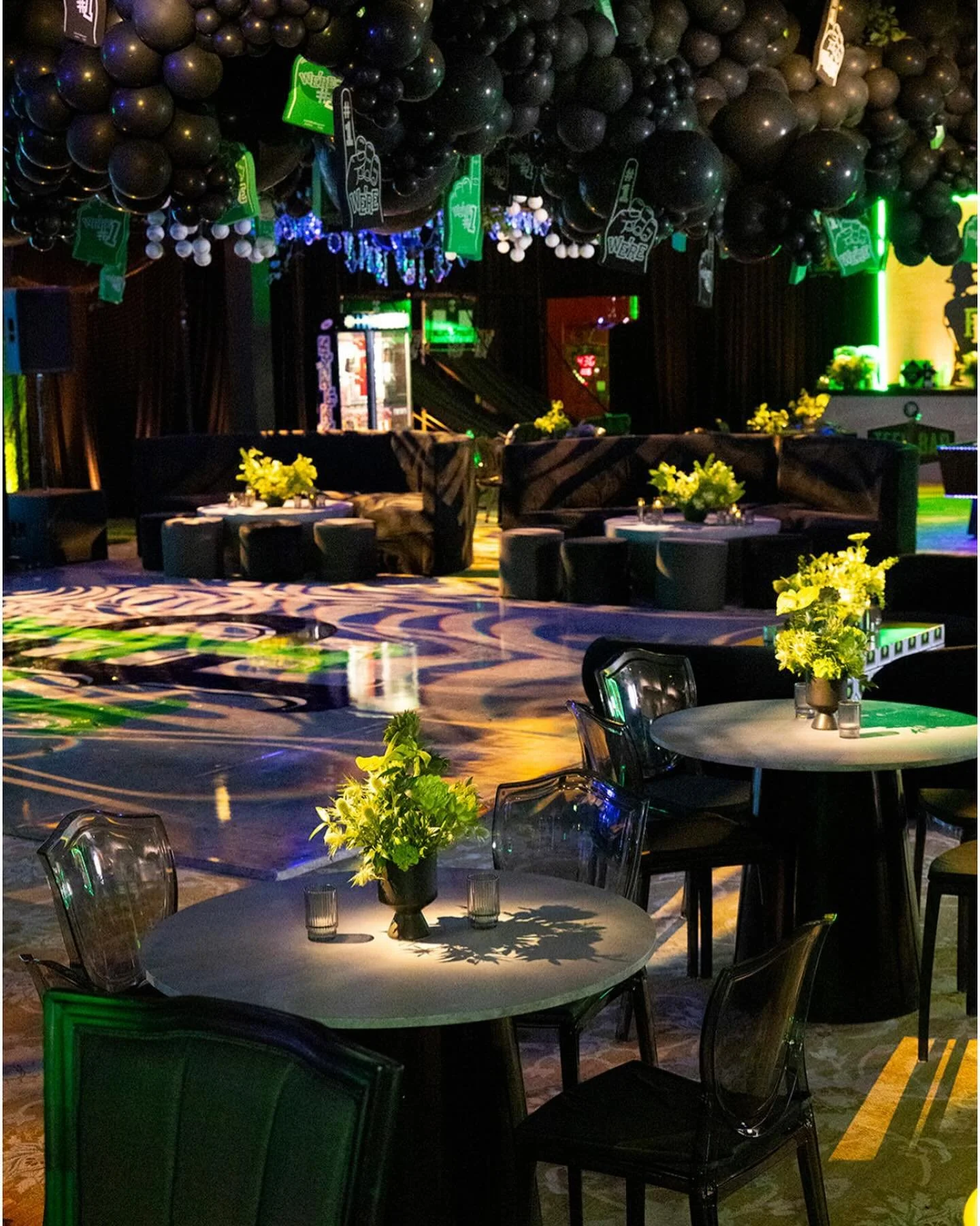 A league of its own — baseball-themed ballroom with black balloon ceiling, cocktail tables and yellow florals