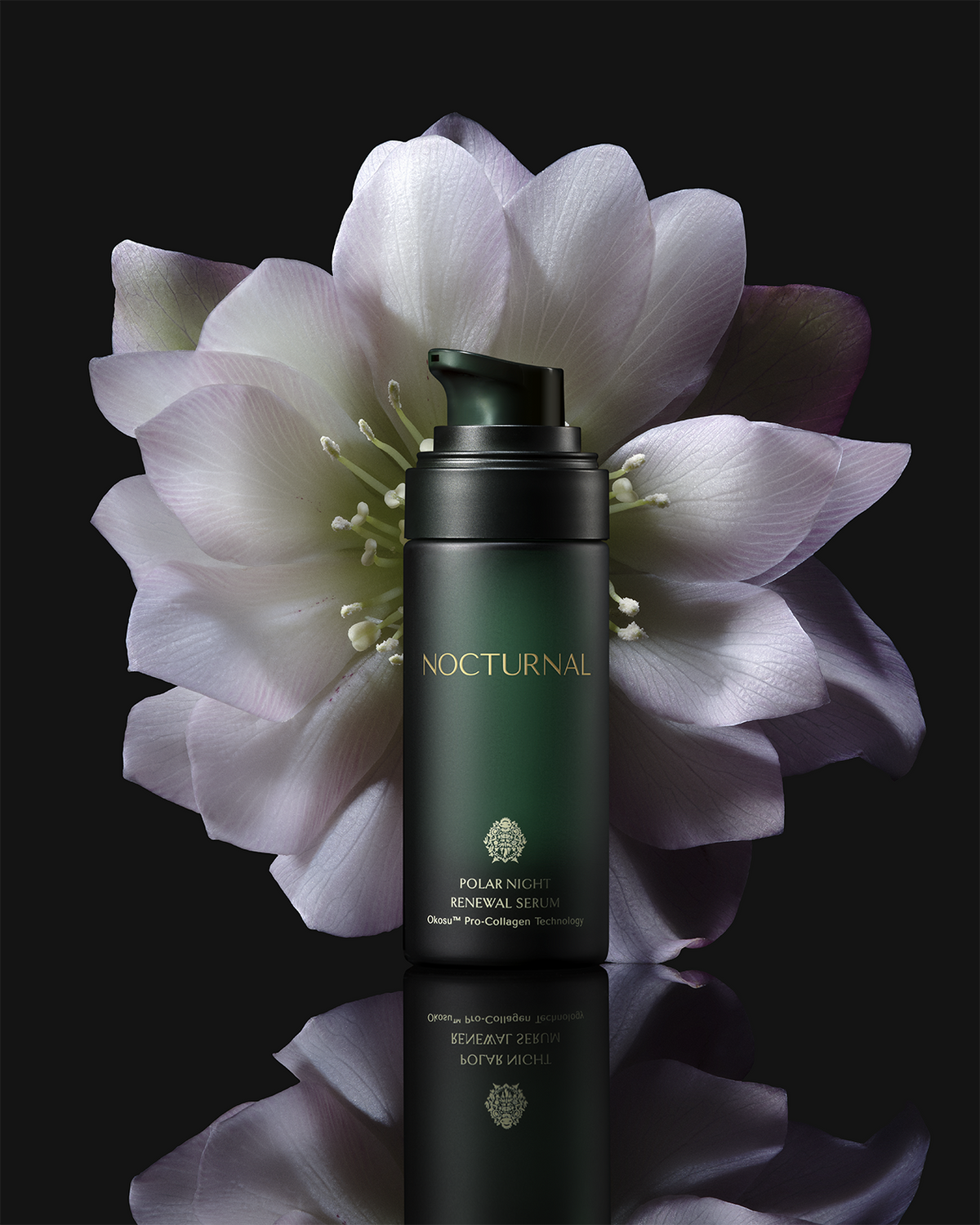Nocturnal Polar Night Renewal Serum dark green pump bottle against a white flower on a black reflective surface.