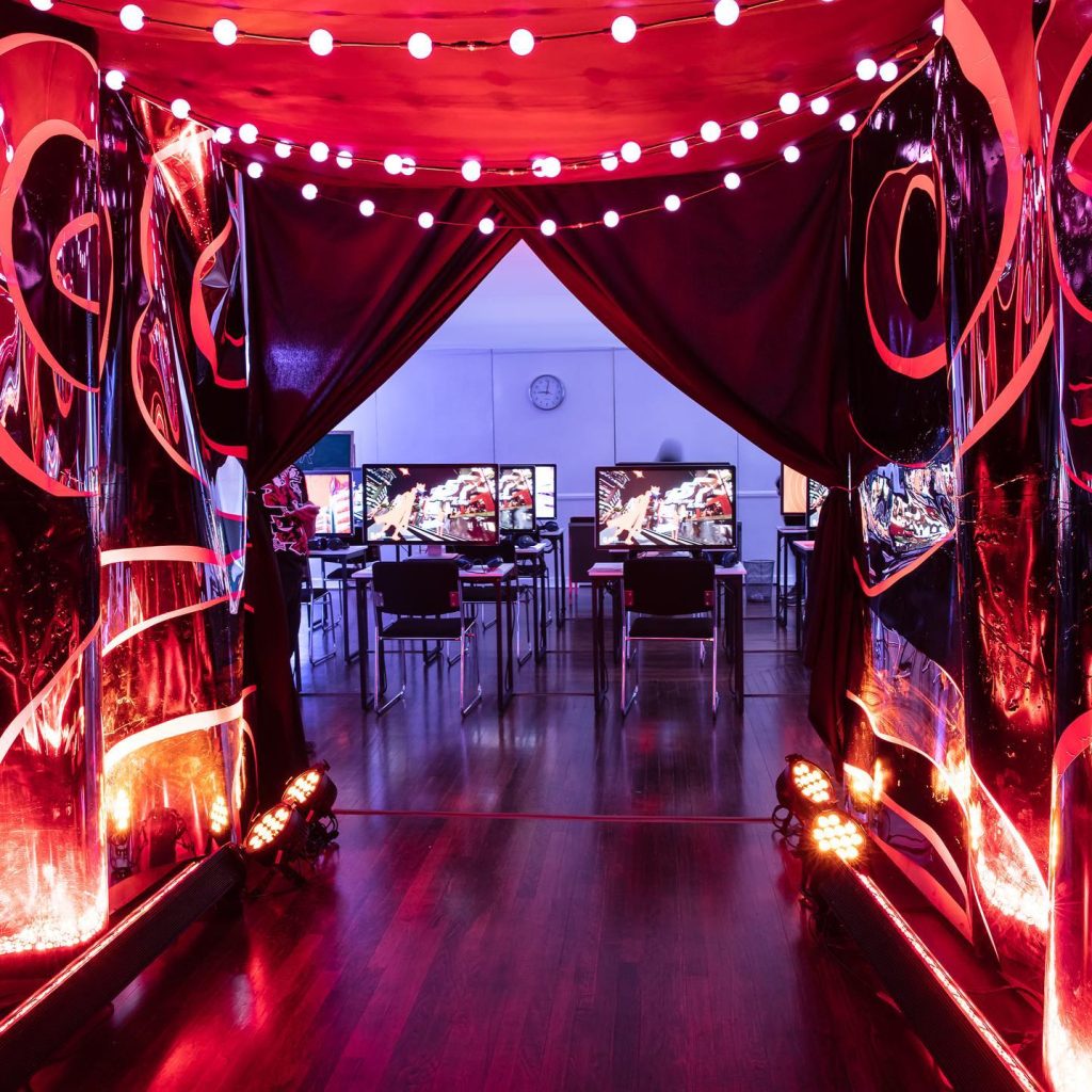 Red-lit event entrance tunnel with string lights