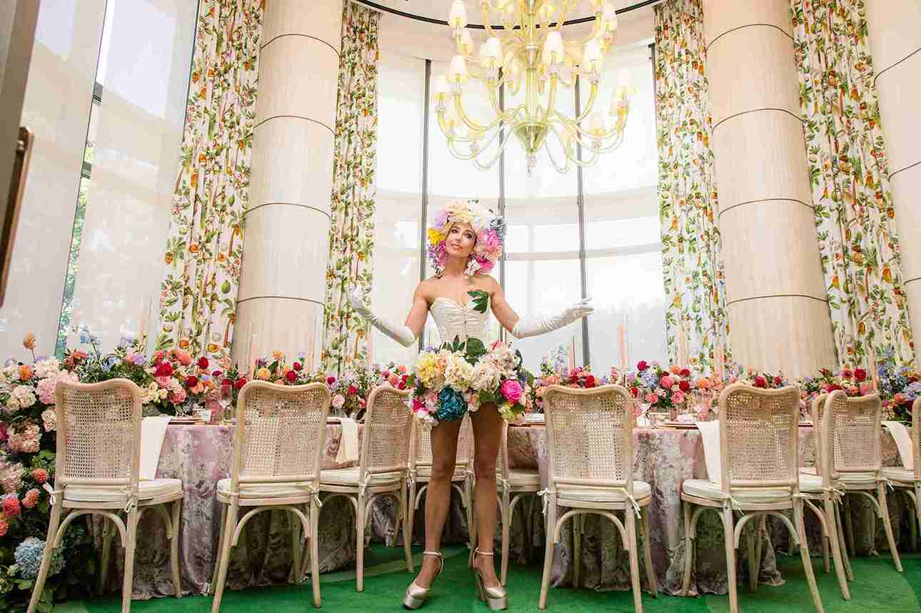 Performer in floral headdress at an elaborately floral-decorated ballroom table