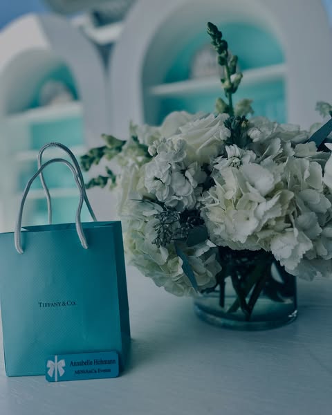 Tiffany & Co. branded gift bag with white floral arrangement, an event detail