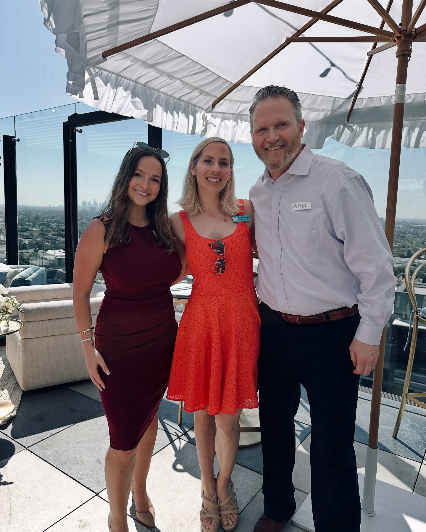 Guests posing on a high-rise rooftop venue with panoramic city views