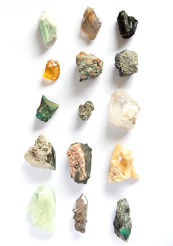 Assorted raw crystals and gemstones arranged in a grid