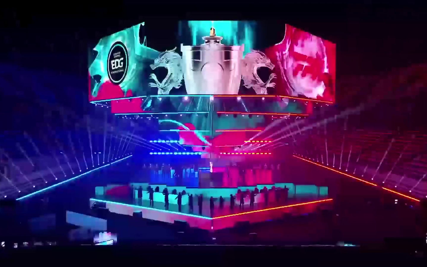 Esports arena stage with EDG branding and the Summoner's Cup on LED screens during a dramatic light show