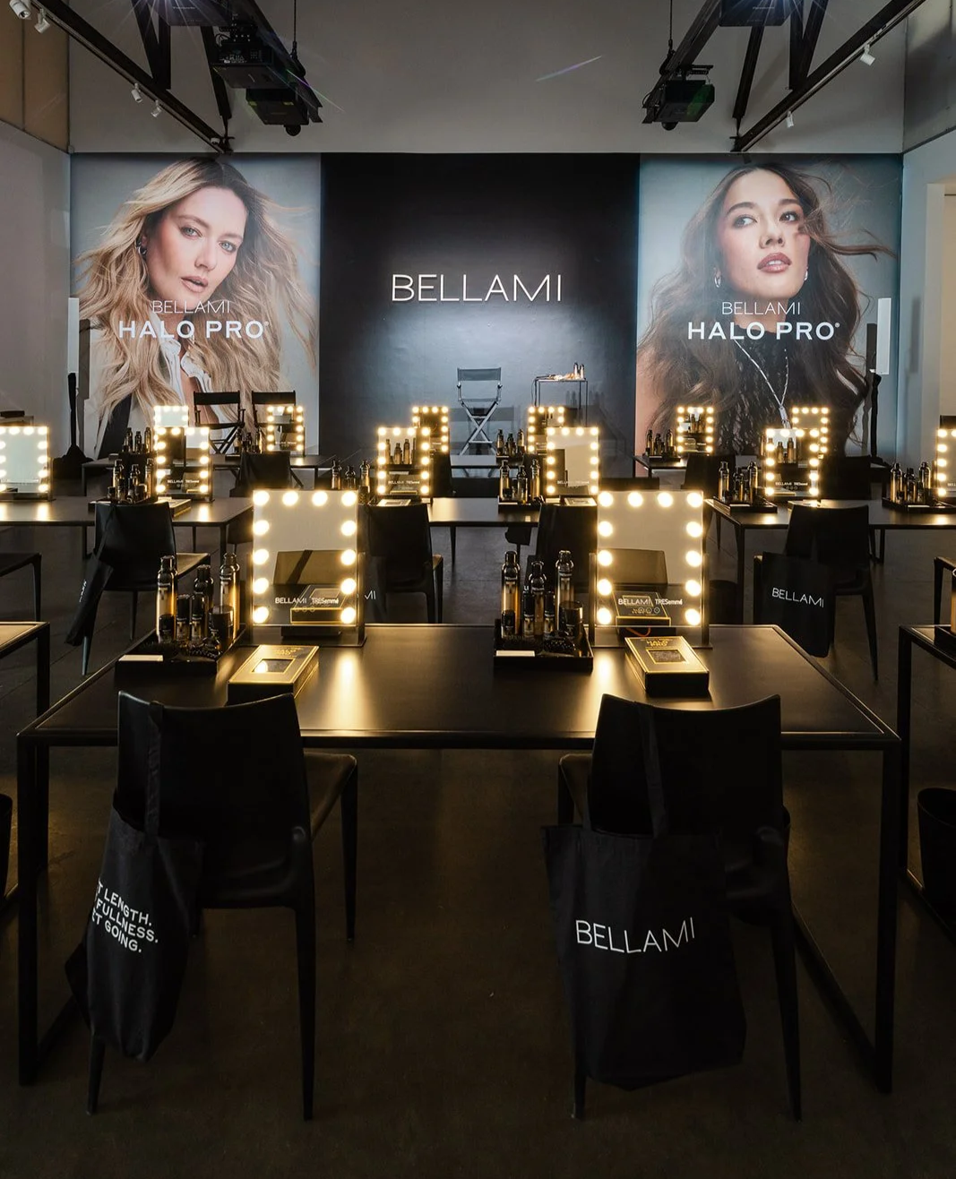 Bellami Halo Pro Masterclass event space empty setup with lit vanity mirrors on black tables and brand backdrop