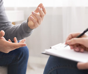 A one-on-one coaching session — one person gesturing while another takes notes.