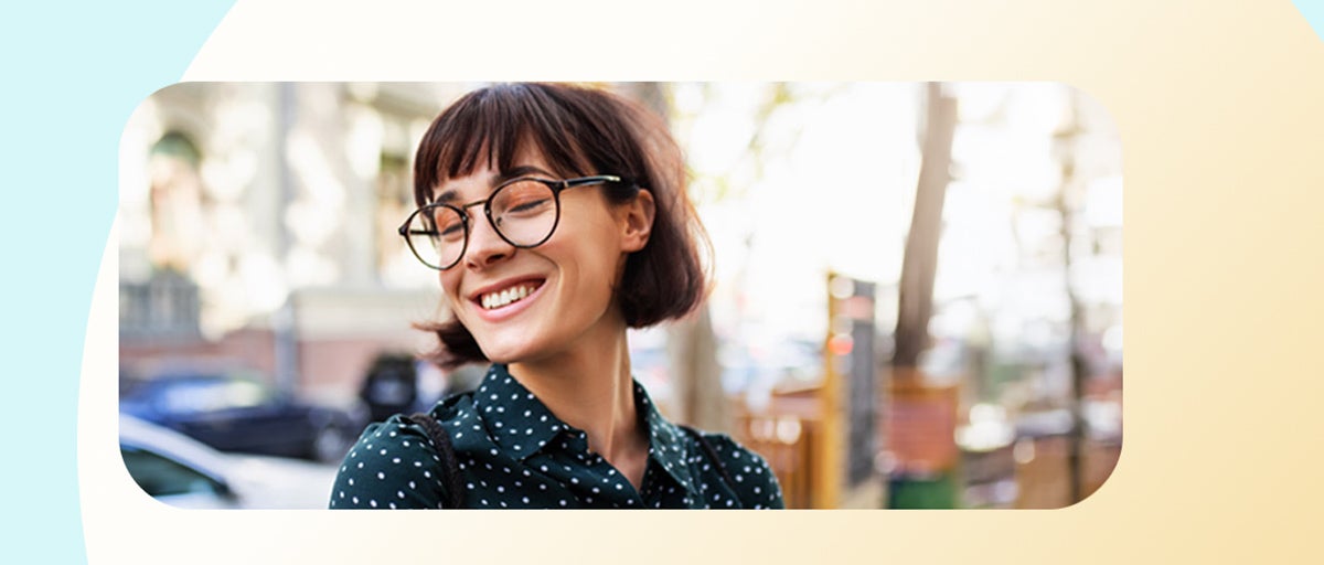 Smiling young woman with glasses outdoors