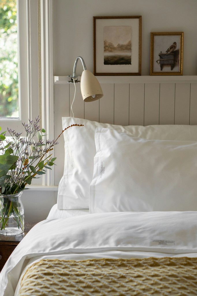 Neatly made bed with white linens