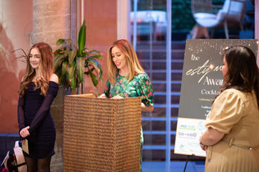 Two women at a podium at an awards cocktail event
