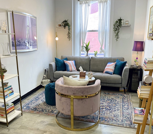 Cozy LK Nutrition counseling room with a gray sofa, teal pillows and a pink velvet chair