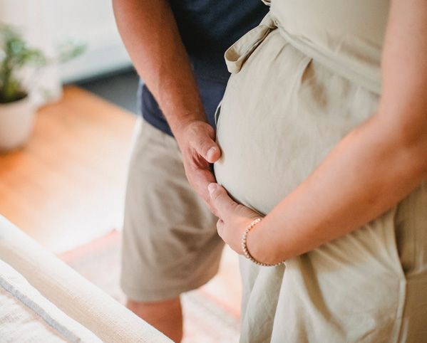 Couple cradling a pregnant belly