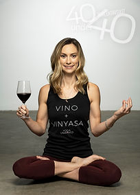 Morgan Perry in meditation pose holding a glass of red wine