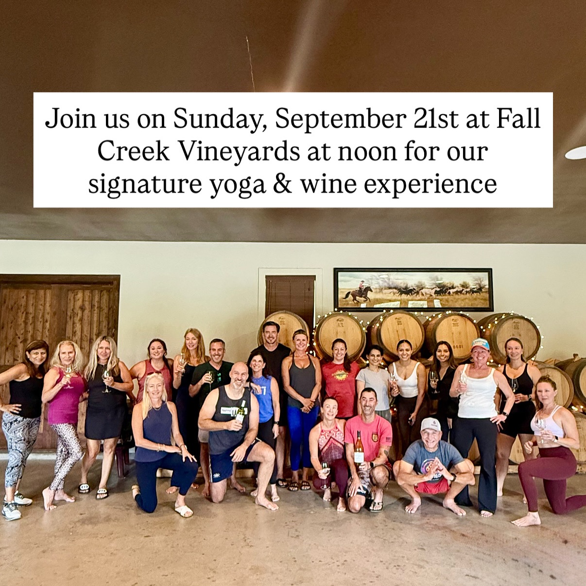 Large group posing in front of wine barrels at Fall Creek Vineyards